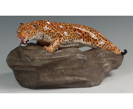 A large Royal Doulton ceramic figure of a leopard, raised on a rocky outcrop, the underglaze painted 'Felidae in stalking pos