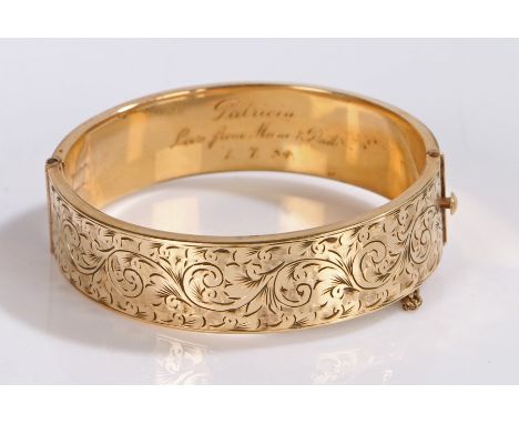 Gold plated bangle, the body with scroll and foliate decoration to one half, the interior stamped 9 ct gold metal core, gross