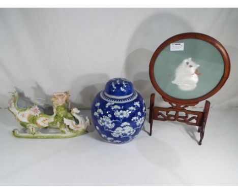 An antique blue and white lidded ginger jar 22 cm (h) and a ceramic continental figurine depicting a female nude on a sleigh 