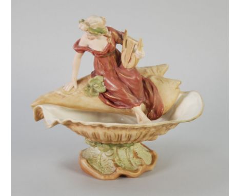 ROYAL DUX ART NOUVEAU PORCELAIN FIGURAL BOWL, painted in muted tones and gilt and modelled as a shell shaped bowl surmounted 