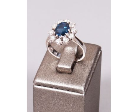 Saphir-Ring, 750er Weißgold schlanke Ringschiene mit ovalem, durchbrochen gearbeitetem Kopf, besetzt mit zentralem, facettier