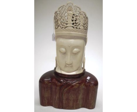 Oriental carved ivory Buddha figure the Head of Buddha surmounted by a carved, pierced crown, on carved wood robe form base, 