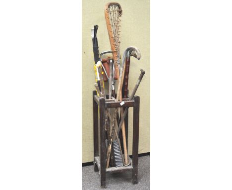 An oak stick stand containing assorted walking sticks