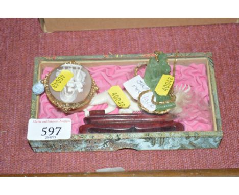 A carved dragon on stand together with a jade type pendant and a yellow metal cameo brooch
