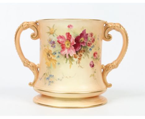 A large Royal Worcester twin handled loving cup. Blush ground, with gilt edging and painted with flowers. Printed puce mark, 