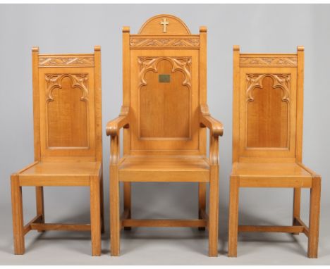 A Puginistic light oak armchair and pair of side chairs. The arm chair with a brass crucifix and presentation plaque, makers 