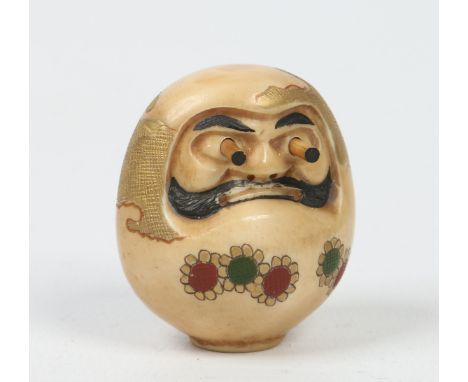 A Japanese Meiji period carved ivory and parcel gilt netsuke of Daruma, with incised painted details and pop out eyes. Signed