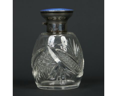 A cut glass scent bottle with hinged silver cover having engine turned blue enamel top. Assayed Birmingham 1927, 10.5cm. Cond