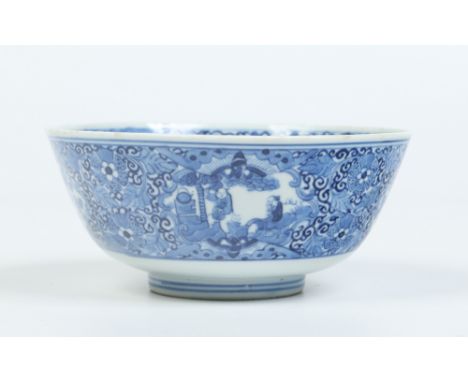 An antique Chinese small bowl. Painted in underglaze blue with stylized foliage, having shaped reserves containing figures, a