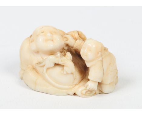 A Japanese carved ivory netsuke. Formed as a man, a young child and a pair of fighting rats. Carved to the underside with a f