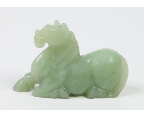 A 20th century Chinese carved celadon jade model of a recumbent horse in Tang style, 9.5cm. Condition Report. To be used as a