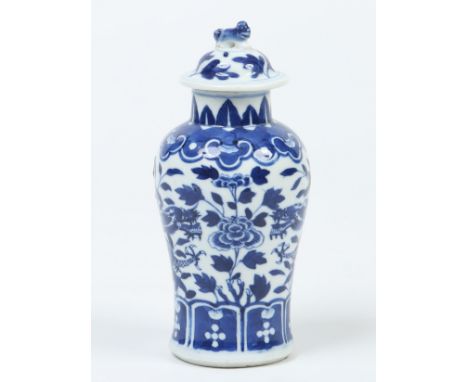 A Chinese late Qing dynasty small baluster vase and cover. Decorated in underglaze blue with a pair of dragons on a foliate g