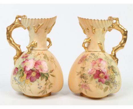 A pair of Royal Worcester blush ground ewers of quatrefoil form and with naturalistic coral moulded handles. Heightened in gi