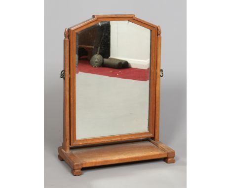An Arts & Crafts oak toilet mirror. With stylized acorn finials and bevelled glass, 60 cm. Condition Report. To be used as a 