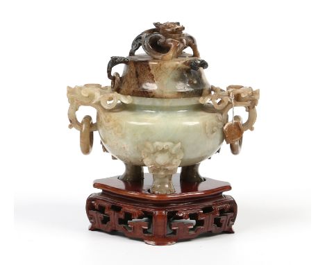 A Chinese 20th century "chicken bone" jade censor and cover. Carved with mythical creatures and raised on three paw feet over