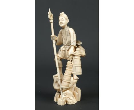 A Japanese Meiji period carved ivory sectional okimono. Formed as a fisherman climbing a rocky outcrop, holding a trident and