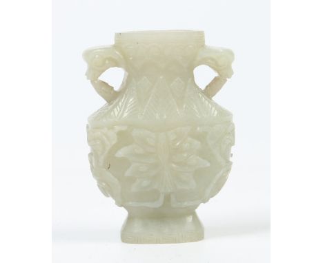 A Chinese Qing dynasty celadon jade twin handled pedestal vase of small proportions with incised key fret borders. Carved wit