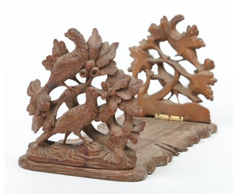 A 19th century Black Forrest carved oak sliding book rack. Ornamented to each side with a pair of birds and foliage. 40cm wid