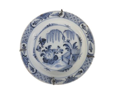18TH CENTURY DELFTWARE CHARGER in blue and white, with a central chinoiserie scene, in a floral border