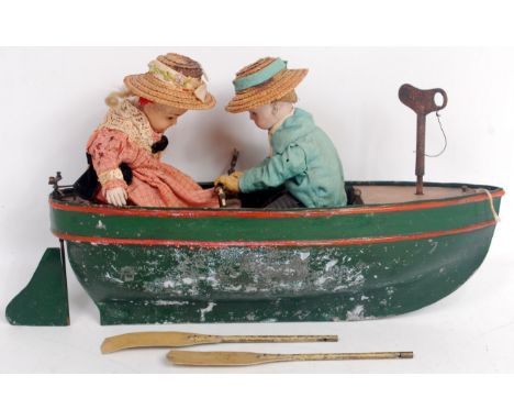 An early 20th century clockwork rowing boat toy, comprising metal hulled (zinc?) painted boat with clockwork motor wound via 