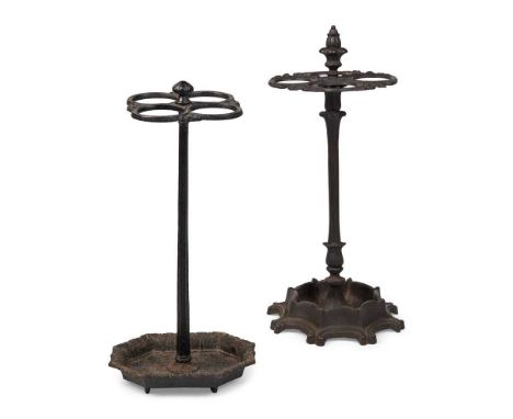 TWO CAST IRON STICK STANDS 19TH CENTURY each with four circular stick holders, one with an octagonal C scroll cast tray base,