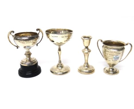 A silver trophy cup, Birmingham 1951, together with three further silver trophy cups and a single silver candlestick, the bas