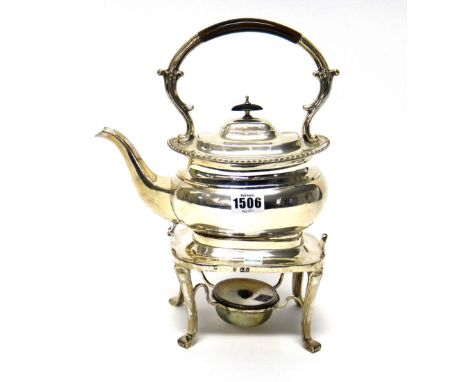 A silver spirit kettle, of compressed form, decorated with a gadrooned rim, having black fittings, with a spirit burner stand