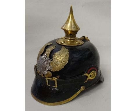 A Perussian Picklehaub style helmet with brass spike and applied crest, painted cockades and leather lining.