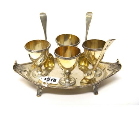 A Victorian silver egg cruet, London 1889 maker J.B., oval with leafy handles, four beaded egg cups and three gilt bowl egg s