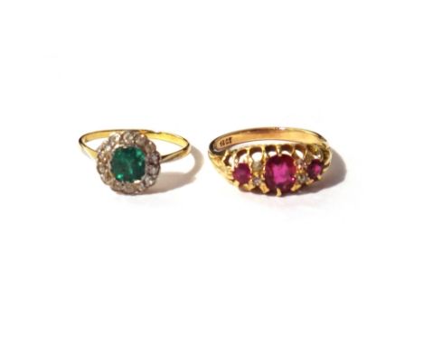 A gold, emerald and diamond set cluster ring, mounted with the cushion shaped emerald at the centre, within a surround of cus