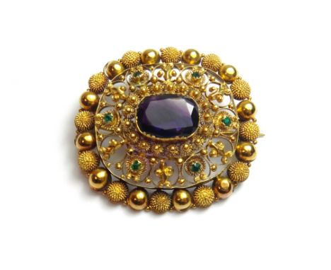 A Victorian gold, amethyst and green gem set brooch, in an oval filigree design mounted with the cushion shaped amethyst at t