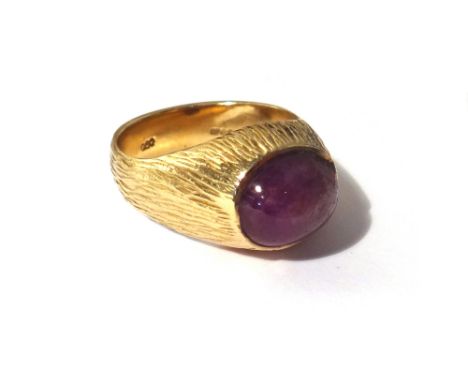 A 9ct gold ring, mounted with an oval cabochon ruby, the mount with bark textured decoration, ring size T and a half, gross w