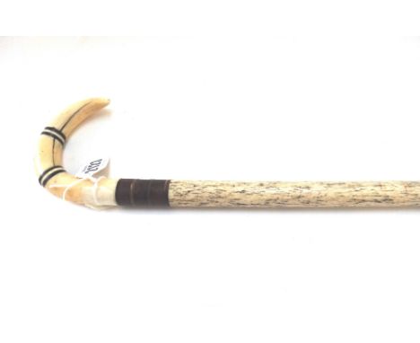 A whale bone walking stick, 19th century of cylindrical tapering form and with a carved whales tooth handle, 94.5cm.