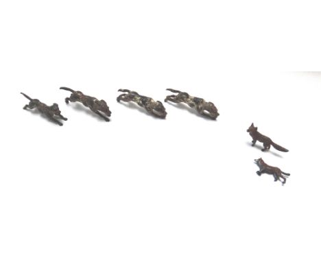 Four cold painted bronze models of hunting hounds, late 19th century (7.5cm) and two smaller cold painted bronze foxes. (a.f.