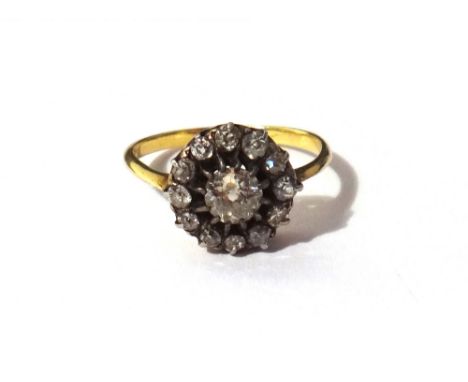 A gold and diamond set cluster ring, claw set with the principal cushion shaped diamond at the centre, within a surround of s