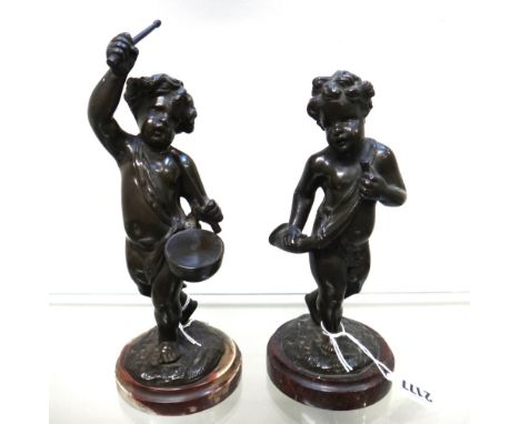After Clodion; a pair of patinated bronze figures, 19th century, each modelled and cast as putto playing musical instruments,