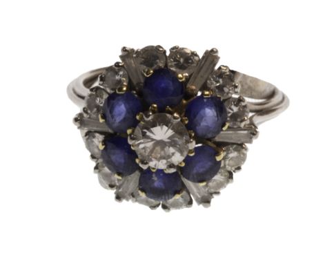 A diamond and sapphire set cluster ring, claw set with the principle circular cut diamond at the centre, within a surround of