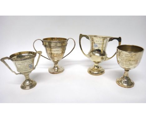 A silver twin handled trophy cup, with partly fluted decoration and three further silver trophy cups, each with a presentatio