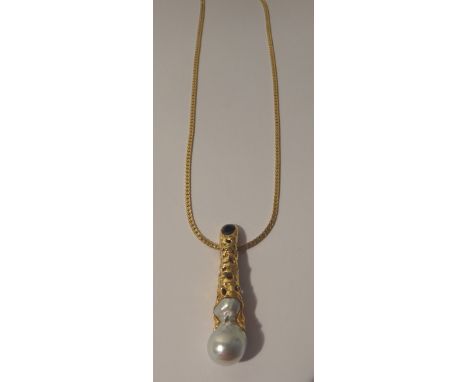 A gold mounted baroque cultured pearl and sapphire set pendant, detailed 750, on a gold flat link necklace, detailed 750, wit