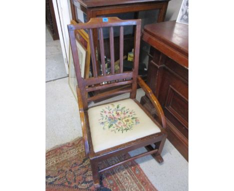 A late 19th century elm framed rocking chair with a tapestry seat, raised on square legs