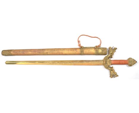 A CHINESE ORNAMENTAL HEAVY CAST BRASS PRESENTATION SWORD AND SCABBARD WITH DRAGON QUILLONS, BOTH ENGRAVED TO HIS EXCELLENCY G