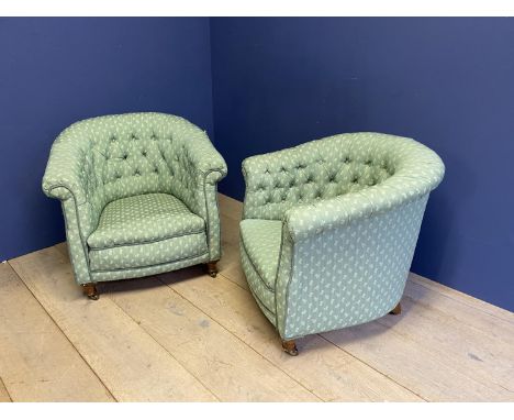 Pair green upholstered button back tub chairs on turned feet and brass casters.  Condition generally good, minor stitching ne