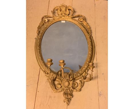 Regency oval wall mirror, set within a decorative gilt wood scrolling border, with shell scrolling finial, and 3 sconce cande