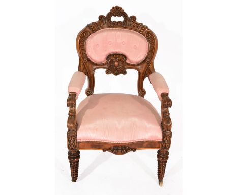 A 19TH CENTURY CARVED WALNUT OPEN ARMCHAIR with shell shaped button upholstered back and scroll supports to the upholstered a