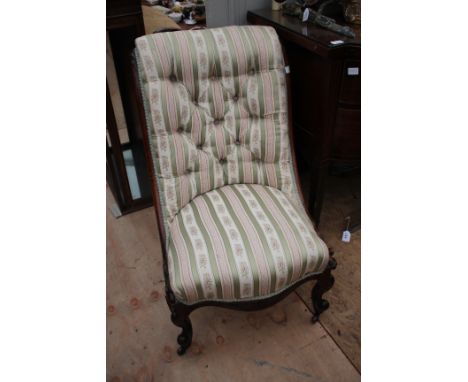 A VICTORIAN OAK BUTTON UPHOLSTERED LOW NURSING CHAIR with serpentine fronted seat and standing on carved legs terminating in 