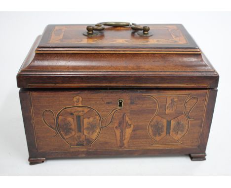 A GEORGIAN MAHOGANY TEA CADDY with scrolling brass swan neck handle and inlaid with various timbers, the front inlaid with te