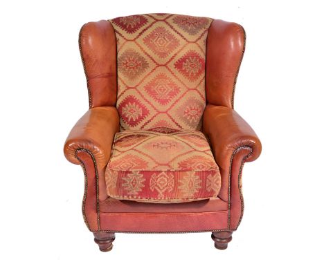 A LARGE CONTEMPORARY WING BACK AND TAPESTRY UPHOLSTERED ARM CHAIR, standing on turned legs