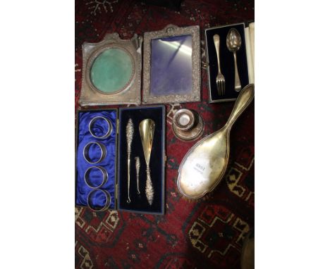 A SMALL GROUP OF SILVER ITEMS to include a silver backed hairbrush, a single candlestick, four napkin rings etc