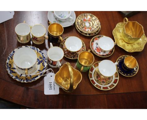 A COLLECTION OF MINIATURE TEA CUPS AND SAUCERS to enclose an example by Coalport decorated in blue and white oak leaves with 