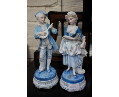 A PAIR OF CONTINENTAL PORCELAIN FIGURES of a gentleman playing a lute and his female companion, each approximately 27cm tall